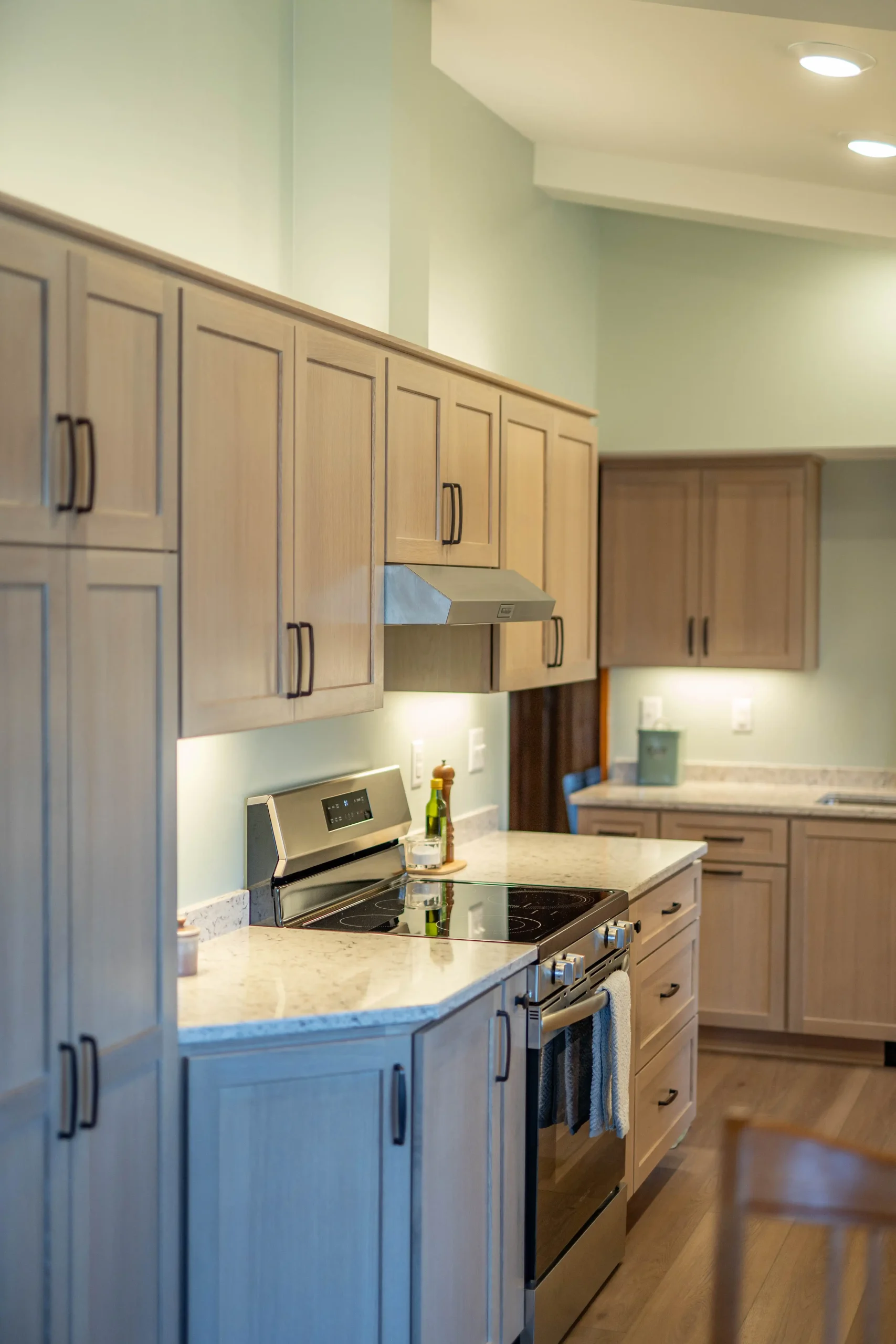 Modern kitchen featuring light wood cabinetry, stainless steel appliances, and a marble countertop, showcasing expert craftsmanship and thoughtful design by Heyday Home Solutions.
